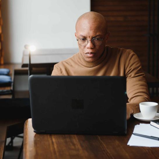 African American man in cafe looking at laptop computer