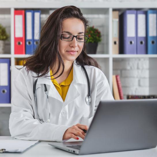 Female physician working on laptop computer
