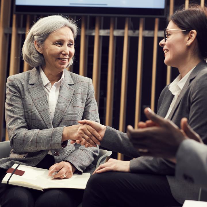 Two women shaking hands and networking