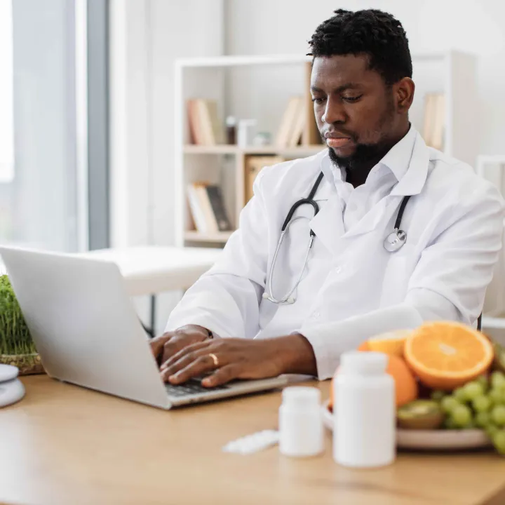 African American physician working on laptop computer