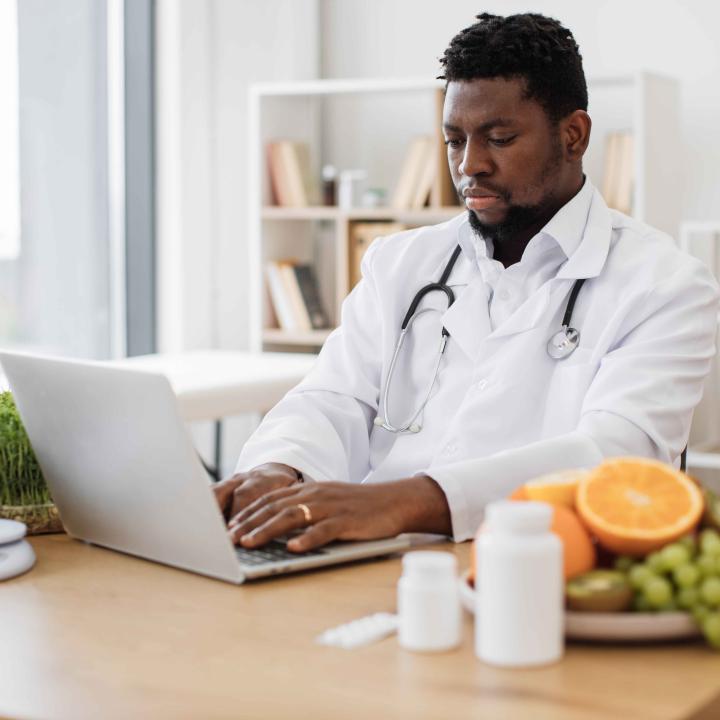 African American physician working on laptop computer