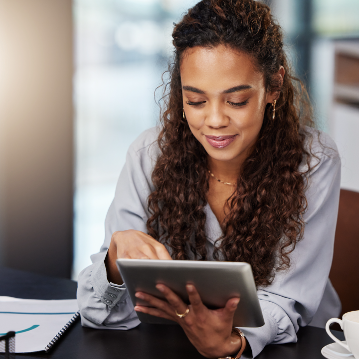 Smiling African American young woman looking at iPad