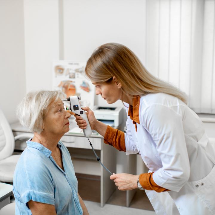 A doctor checks the eye pressure of a senior woman for diabetic eye disease