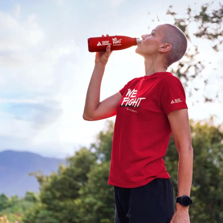 A woman drinks from an ADA water bottle