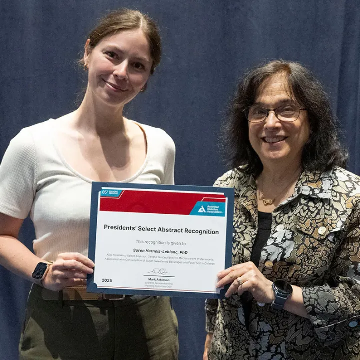 Two diabetes researchers holding abstract reviewer diploma