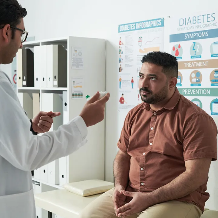 Heavy set man in doctors office talking to doctor