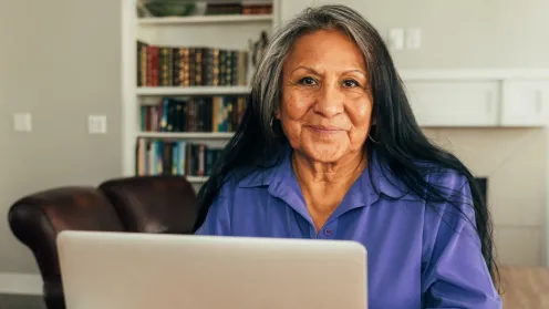 Senior Latina looking at laptop computer