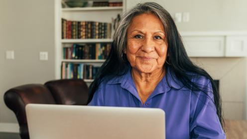 Senior Latina looking at laptop computer