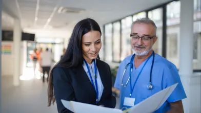 Health care administrator and physician discussing a patient's chart