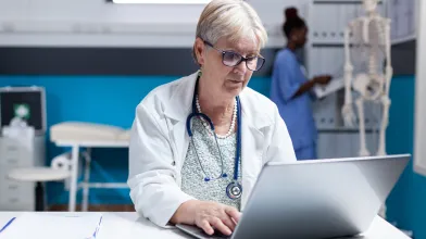 Senior female physician at laptop computer