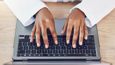 African American typing on laptop computer