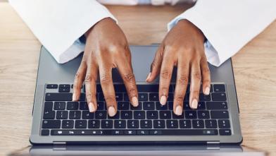 African American typing on laptop computer