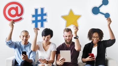 Group of people holding up social media symbols