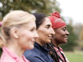 Three racially mixed middle-aged women standing outside