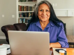 Senior Latina looking at laptop computer