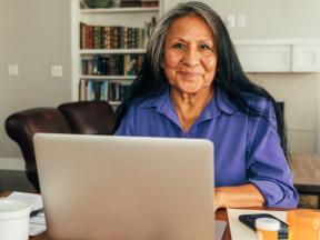 Senior Latina looking at laptop computer