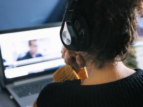 Woman with headphones watching online class