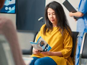 Woman looking at brochure in waiting room at doctor office