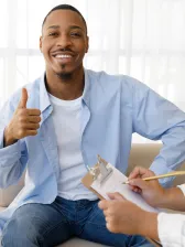 Smiling young African American man smiling and giving a thumbs up