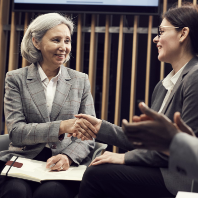 Two women shaking hands and networking