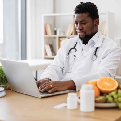 African American physician working on laptop computer