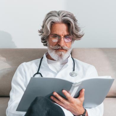 Senior male physician reading a report