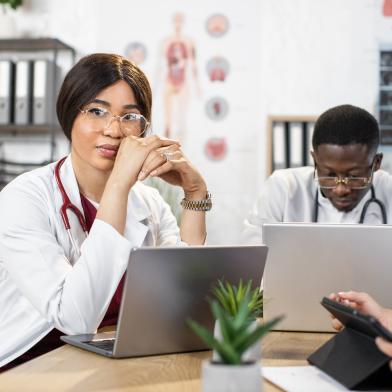 African American doctors at desk with laptop computers