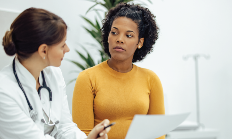 Woman doctor talking to African American woman patient