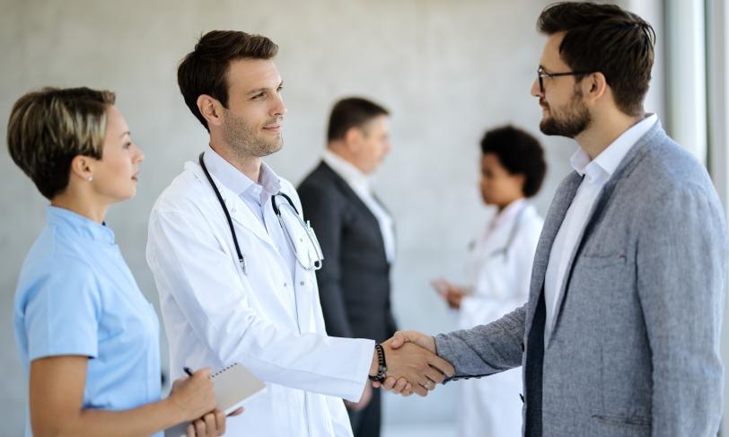 Male Doctor handshake with businessman