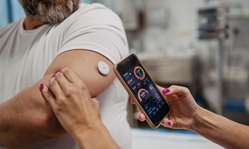 A doctor scans a CGM on a person's arm
