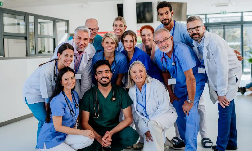 Smiling group of doctors and nurses in hospital lobby