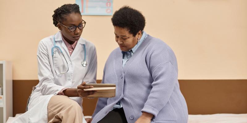 African American woman physician speaking to obese African American woman