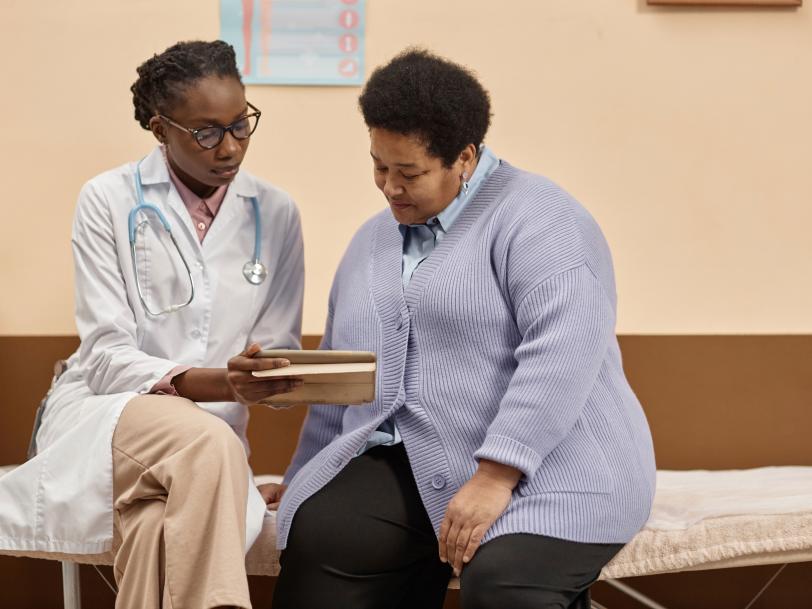 African American woman physician speaking to obese African American woman