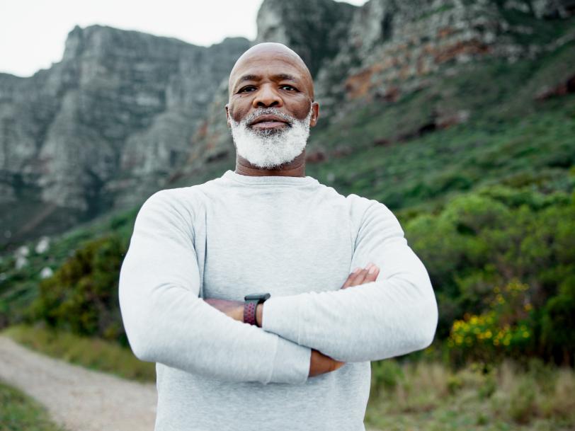 Senior African American man standing outside with arms crossed