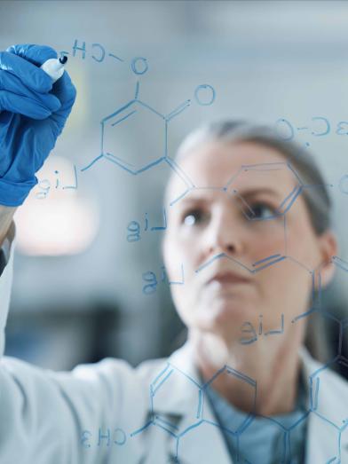 Female researcher writing molecular breakdown on glass