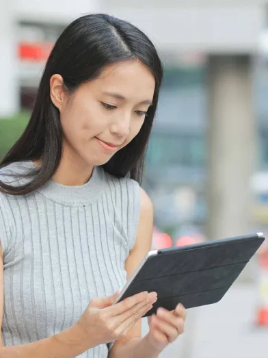 Woman looking at tablet computer outdoors