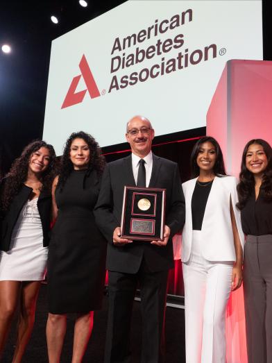 Group of smiling attendees getting award at meeting