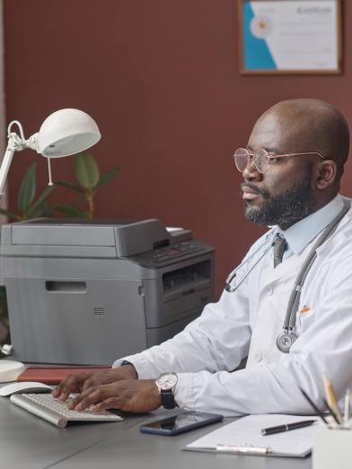 African American physician working at desk on computer