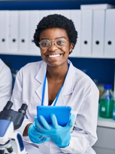 Two young African American scientists smiling in a laboratory setting.