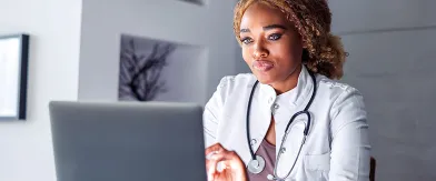 African American physician looking at laptop